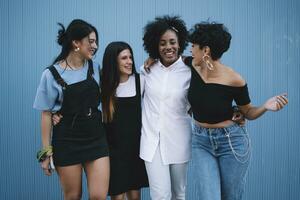 Laughing women in front of a blue wall photo
