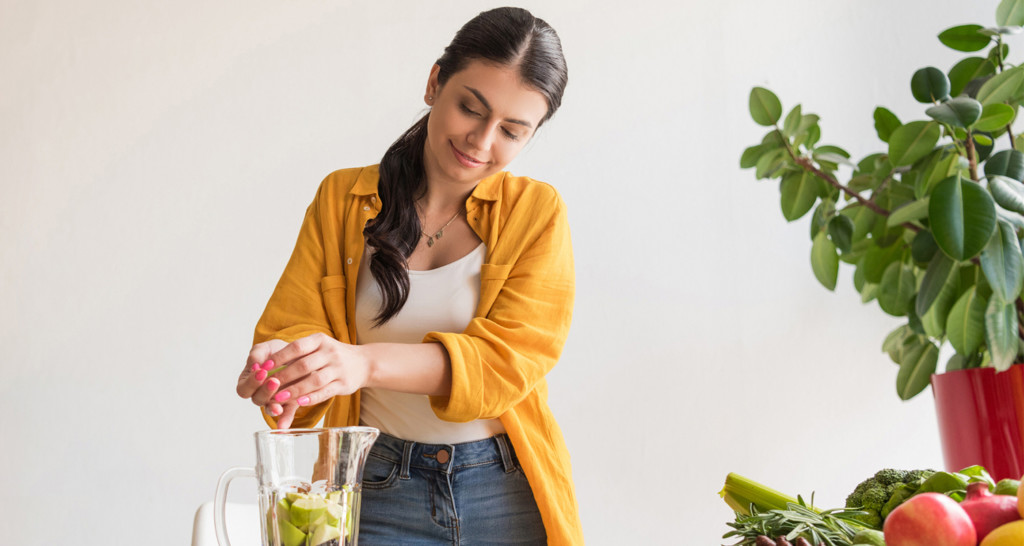 Healthy woman using blender