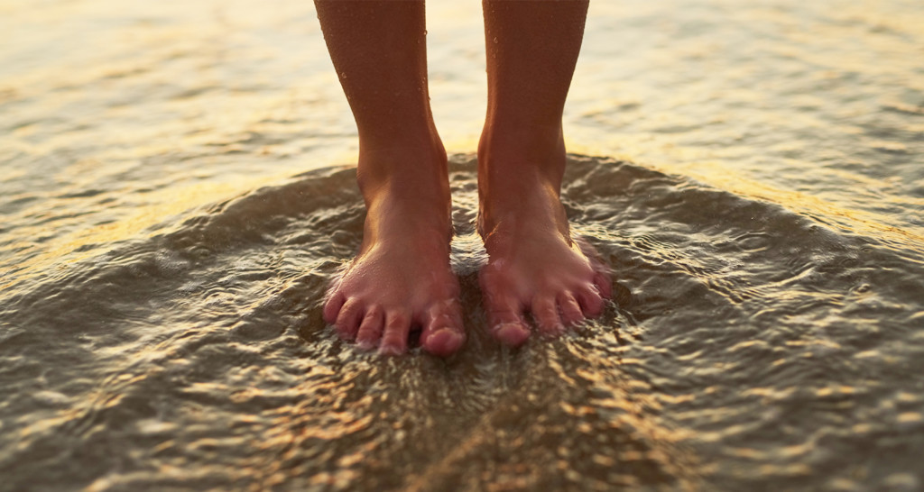 Person standing with feet in sand