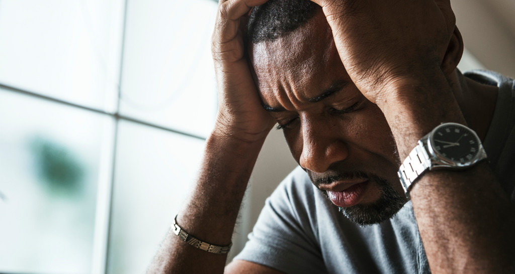 Stressed man with hands at temples