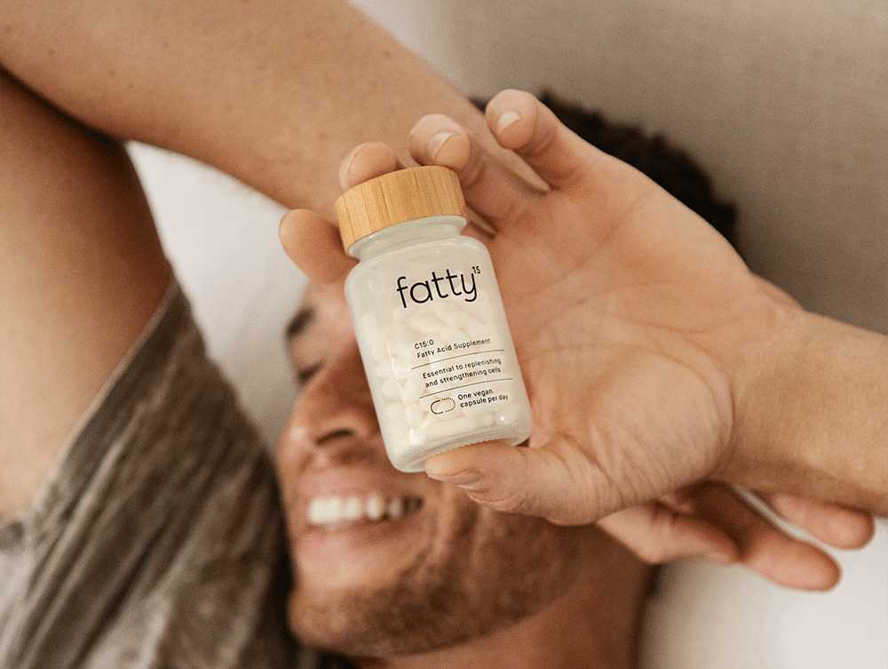 Man holding a bottle of Fatty™ supplements