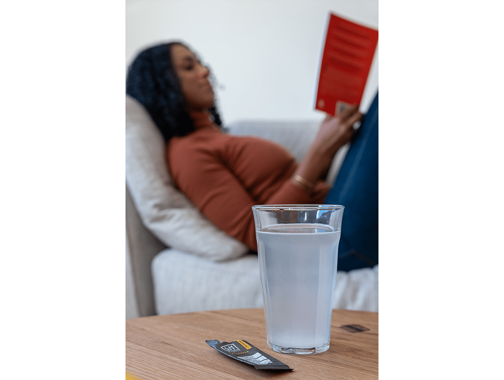 Woman with LMNT drink in glass cup